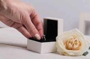 Engagement ring box in bride hands. Closeup of woman hand holding jewellery. Love, Wedding, Proposing, Marriage concept.